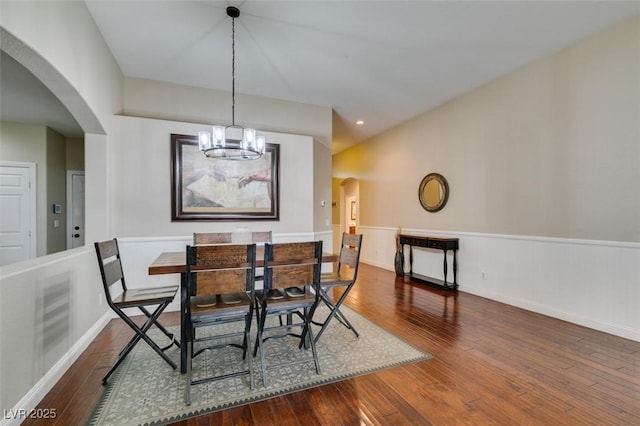 dining space with dark wood-type flooring and an inviting chandelier