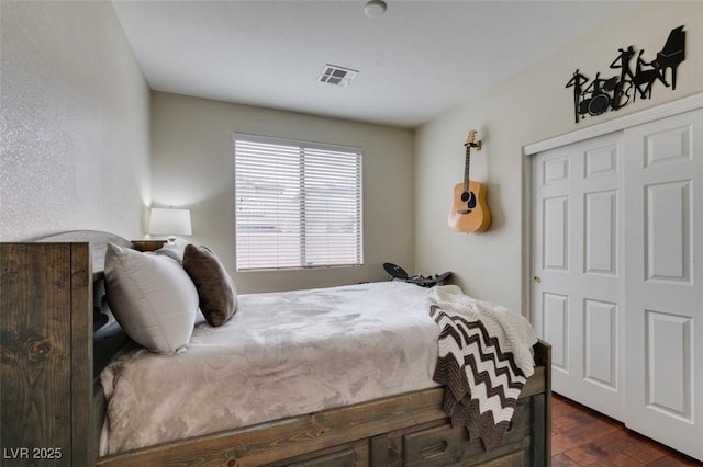 bedroom with dark wood-type flooring and a closet