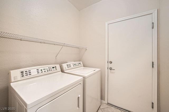 clothes washing area with light tile patterned floors and washing machine and clothes dryer