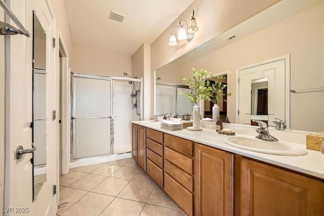 bathroom featuring a shower with door, vanity, and tile patterned floors