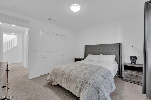 bedroom with light carpet and a closet