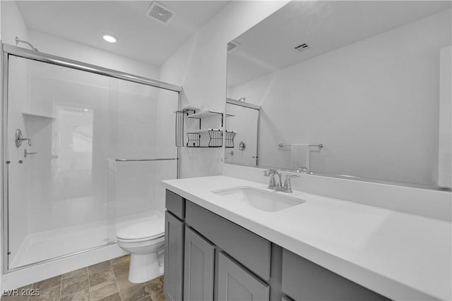 bathroom featuring vanity, toilet, and walk in shower