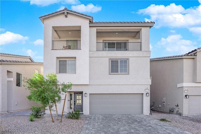 view of front of property featuring a garage and a balcony