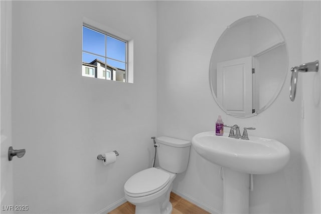 bathroom featuring wood-type flooring and toilet