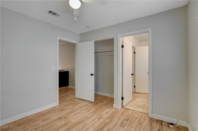 unfurnished bedroom with light hardwood / wood-style flooring, a closet, and ceiling fan