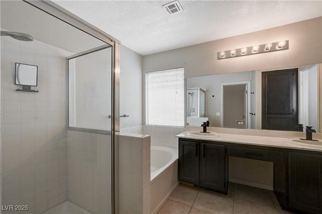 bathroom with vanity, separate shower and tub, tile patterned flooring, and a textured ceiling