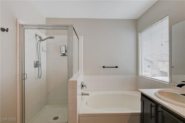 bathroom with independent shower and bath, vanity, and a healthy amount of sunlight