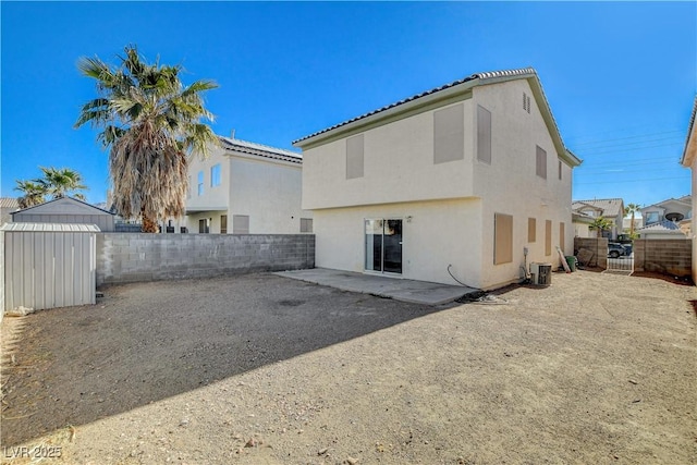 rear view of house featuring a shed, central AC unit, and a patio