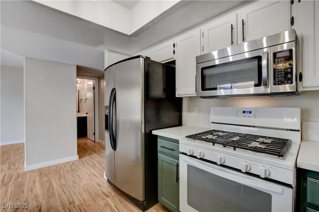 kitchen with white cabinetry, appliances with stainless steel finishes, light hardwood / wood-style floors, and green cabinetry