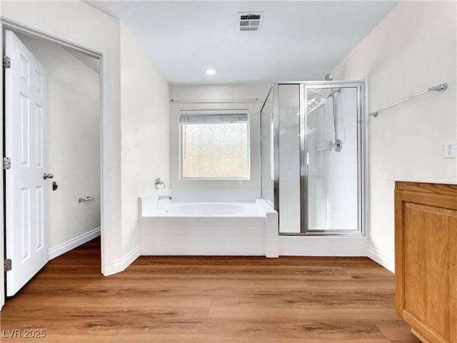 bathroom with hardwood / wood-style flooring and independent shower and bath