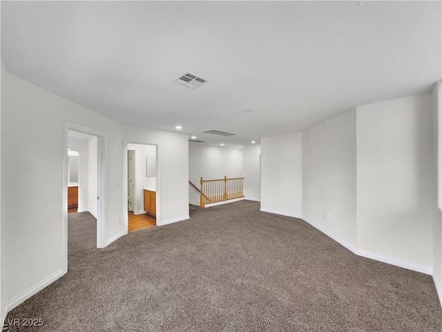 spare room with dark carpet