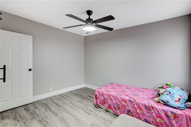 unfurnished bedroom featuring a ceiling fan, light wood-style flooring, and baseboards