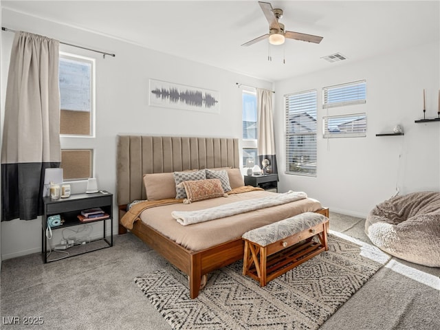 bedroom with multiple windows, light colored carpet, and ceiling fan