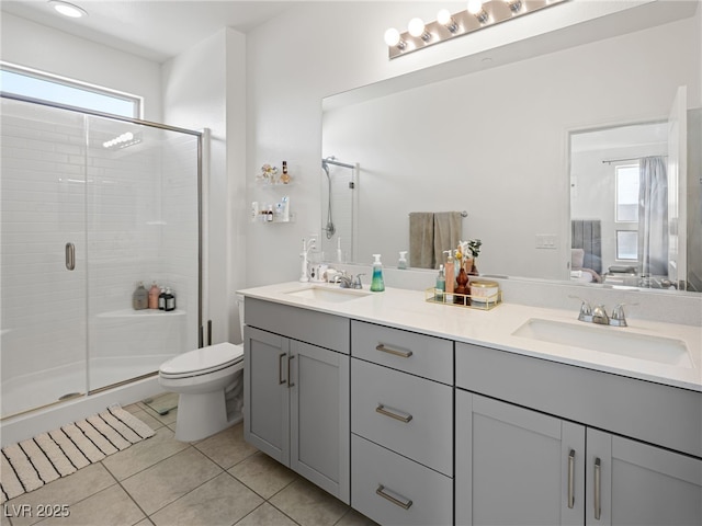 bathroom with tile patterned flooring, vanity, toilet, and walk in shower