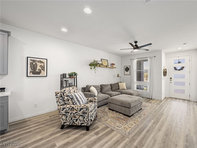 living room with ceiling fan and light hardwood / wood-style flooring