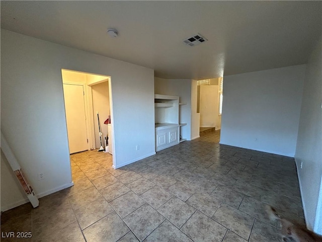 unfurnished room featuring visible vents and baseboards