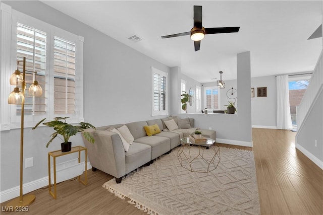 living room featuring wood-type flooring and ceiling fan