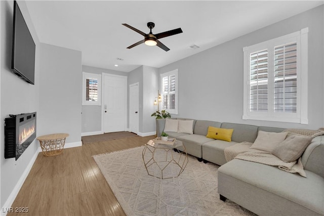 living room featuring wood-type flooring and ceiling fan