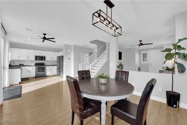 dining space featuring ceiling fan, sink, and light hardwood / wood-style floors