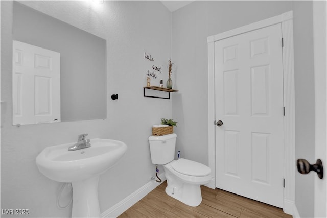 bathroom with hardwood / wood-style floors, sink, and toilet