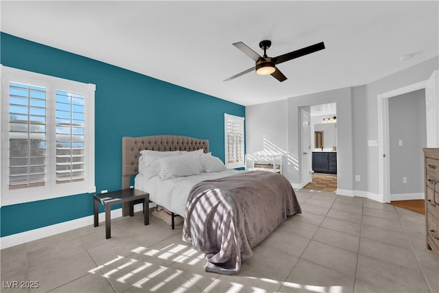 bedroom featuring ceiling fan, ensuite bath, and light tile patterned floors