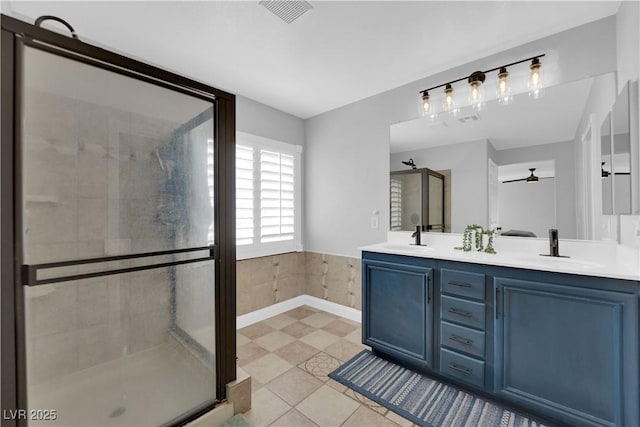 bathroom featuring a shower with door, vanity, and tile patterned floors