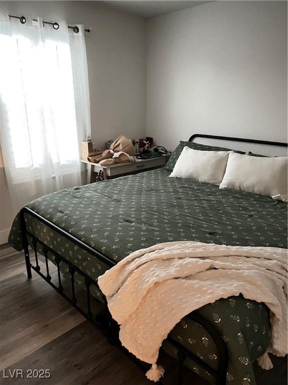 bedroom featuring dark hardwood / wood-style flooring and multiple windows