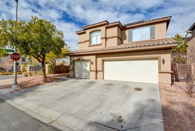 mediterranean / spanish house featuring concrete driveway, fence, an attached garage, and stucco siding