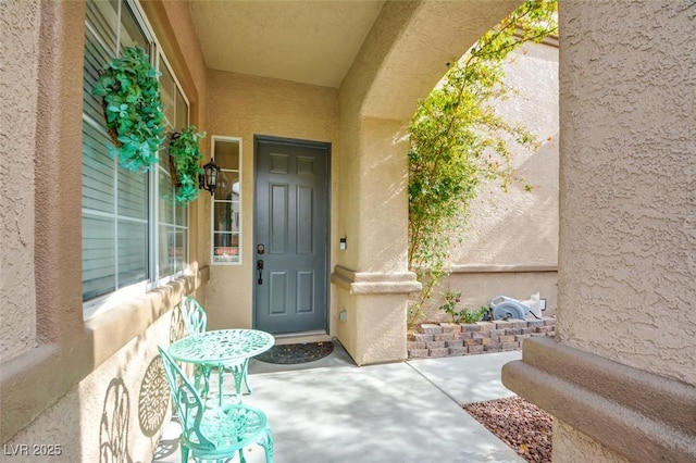 doorway to property featuring stucco siding