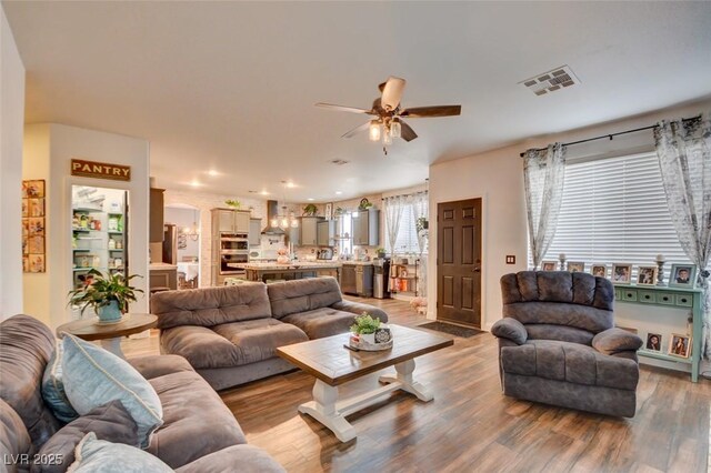 living room with hardwood / wood-style flooring and ceiling fan