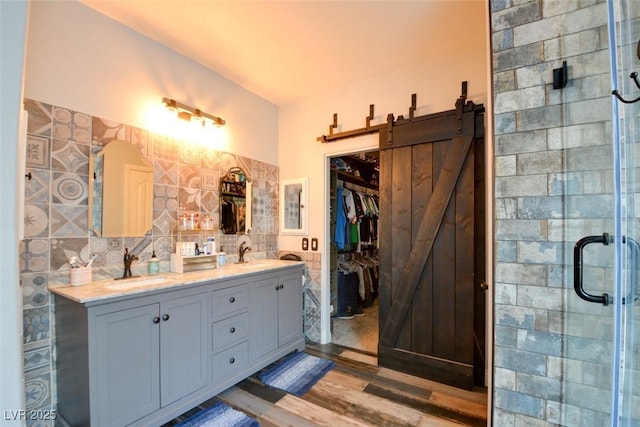 bathroom with walk in shower, vanity, hardwood / wood-style floors, and tile walls