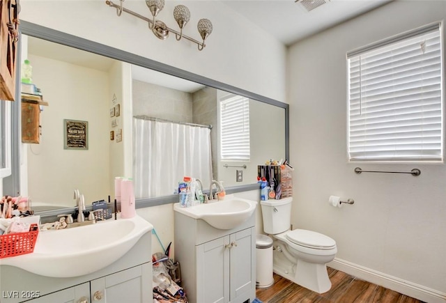 bathroom featuring vanity, toilet, curtained shower, and hardwood / wood-style floors