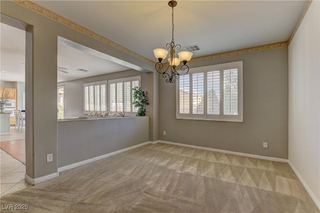 spare room with light colored carpet and a notable chandelier