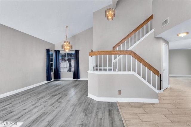 foyer with light hardwood / wood-style flooring, high vaulted ceiling, and a chandelier