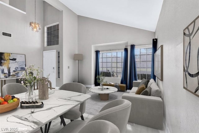 living room with a notable chandelier and high vaulted ceiling