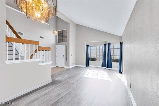 interior space with hardwood / wood-style flooring, a chandelier, and high vaulted ceiling