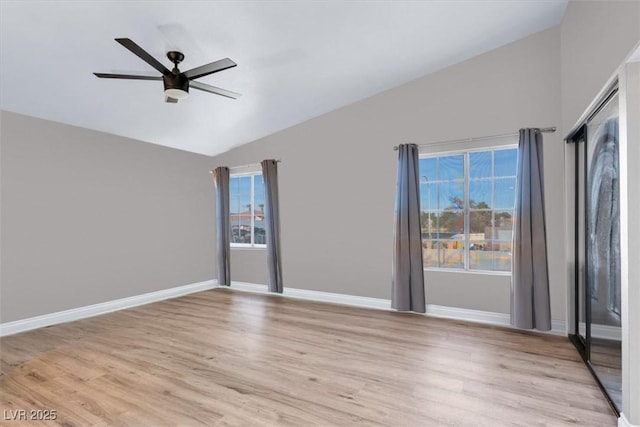 spare room with vaulted ceiling, ceiling fan, and light hardwood / wood-style flooring