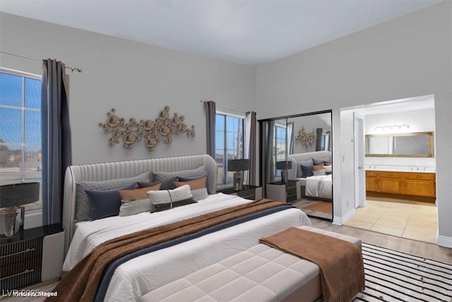 bedroom with light hardwood / wood-style floors and ensuite bathroom