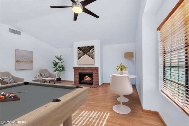 game room with billiards, lofted ceiling, ceiling fan, light hardwood / wood-style floors, and a brick fireplace