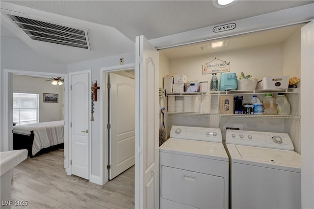 laundry area with ceiling fan, independent washer and dryer, and light hardwood / wood-style floors