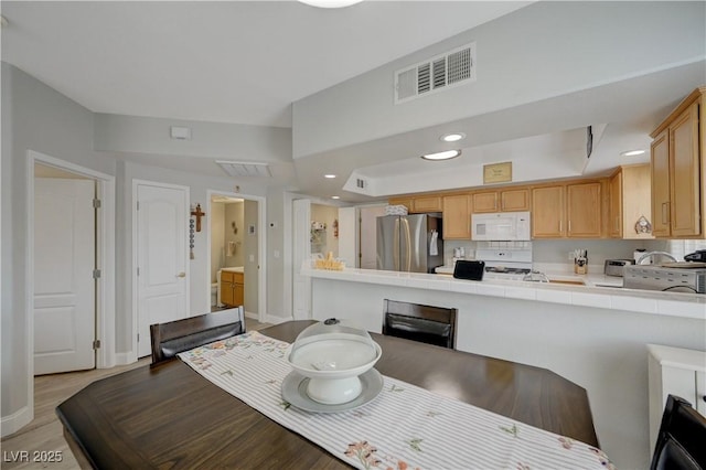 dining space with light hardwood / wood-style flooring