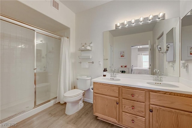 bathroom featuring hardwood / wood-style flooring, vanity, toilet, and an enclosed shower