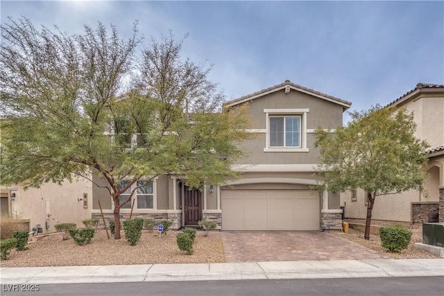 view of front of house featuring stone siding, stucco siding, and decorative driveway