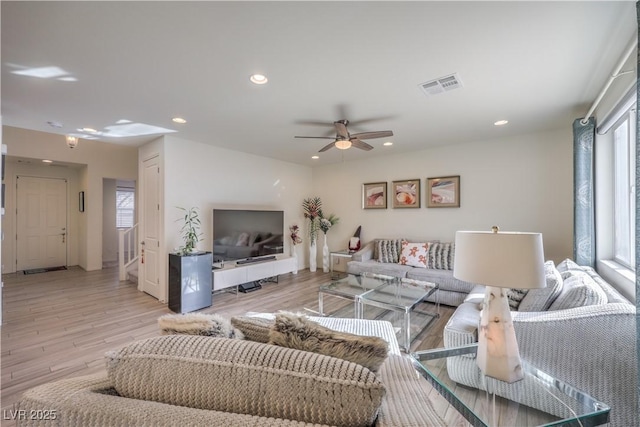 living room featuring ceiling fan, a healthy amount of sunlight, and light wood-type flooring