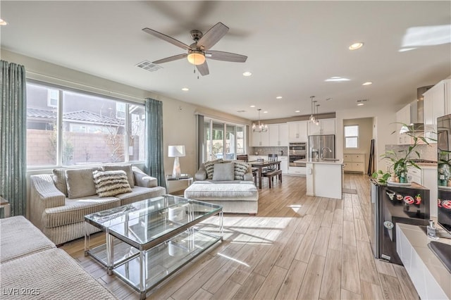 living room with visible vents, recessed lighting, light wood-style floors, and ceiling fan