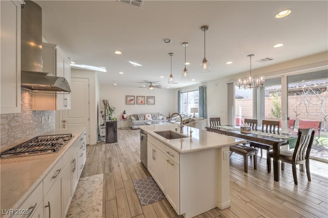 kitchen featuring visible vents, backsplash, open floor plan, light countertops, and wall chimney exhaust hood