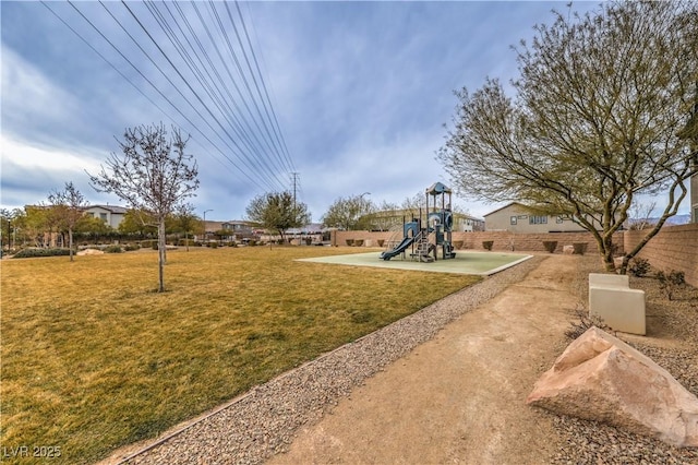 view of property's community with playground community, a yard, and fence