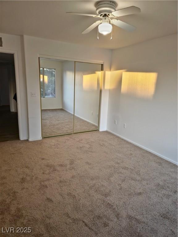 unfurnished bedroom featuring ceiling fan, carpet floors, and a closet