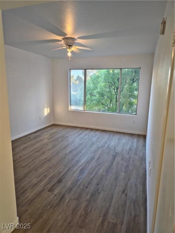 unfurnished room featuring ceiling fan and dark hardwood / wood-style flooring