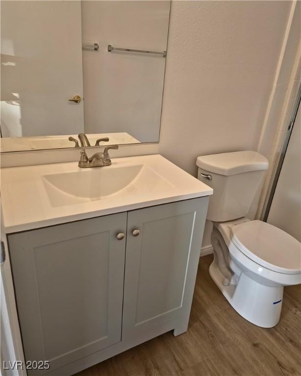 bathroom with vanity, hardwood / wood-style floors, and toilet